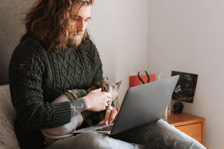 Man with his cat using telehealth to apply for an ESA letter online.